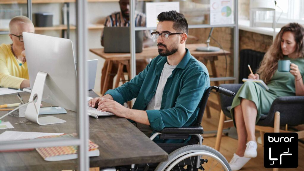 Aménager un bureau pour les personnes en situation de handicap 1 personne en fauteuil roulant travaillant dans un open space
