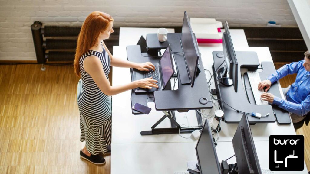 Ergonomie au bureau : comment adapter son poste de travail ? 2 femme travaillant debout